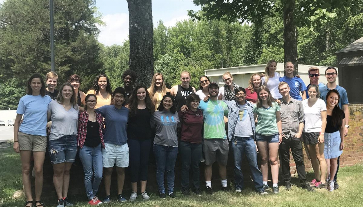 Summer interns pose for a group picture on the grass